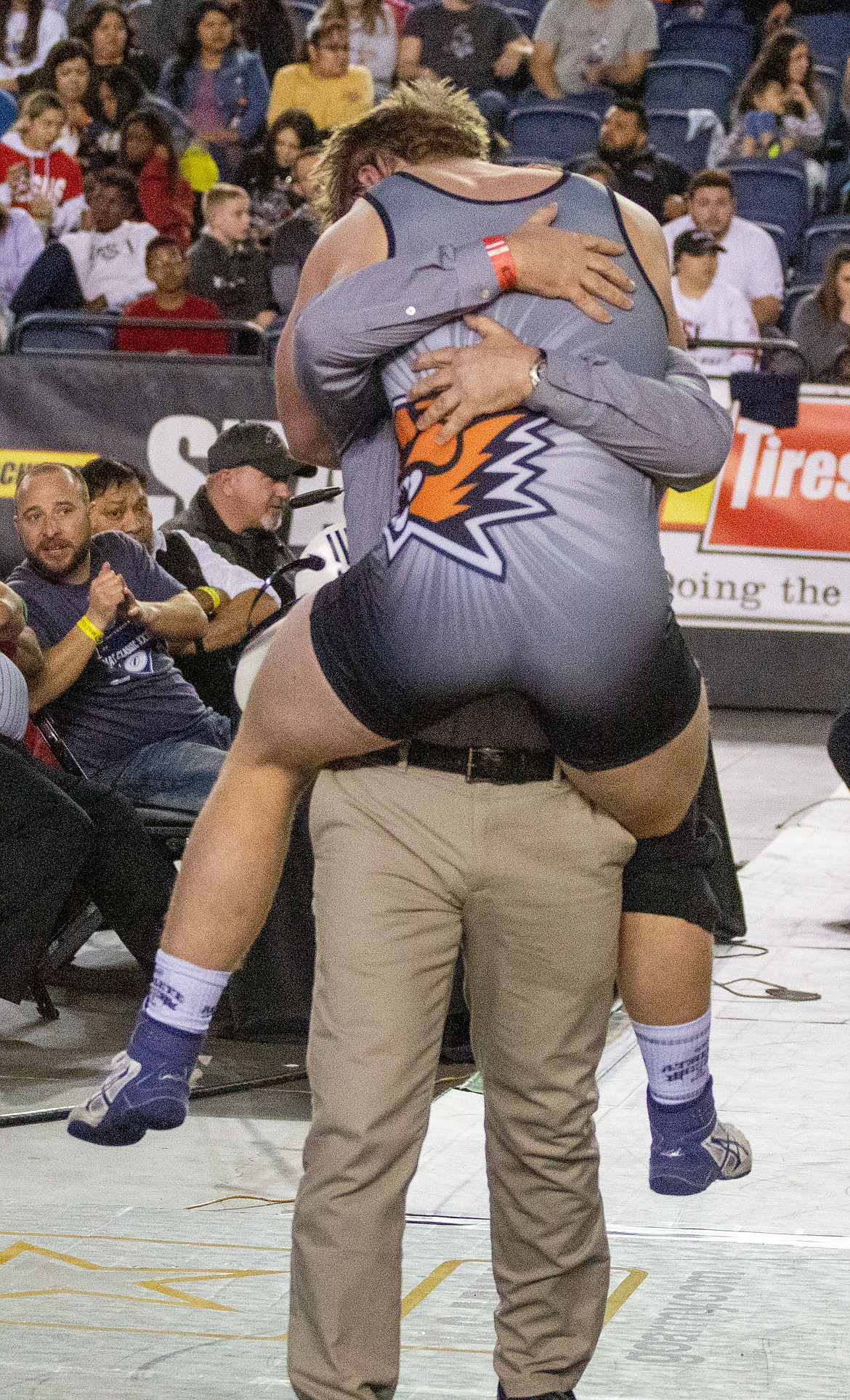 Casey McCarthy/Columbia Basin Herald Mac Laird leaps into the arms of his dad and assistant coach, David, after winning the 2A state championship at 195 at Mat Classic XXXII in Tacoma.