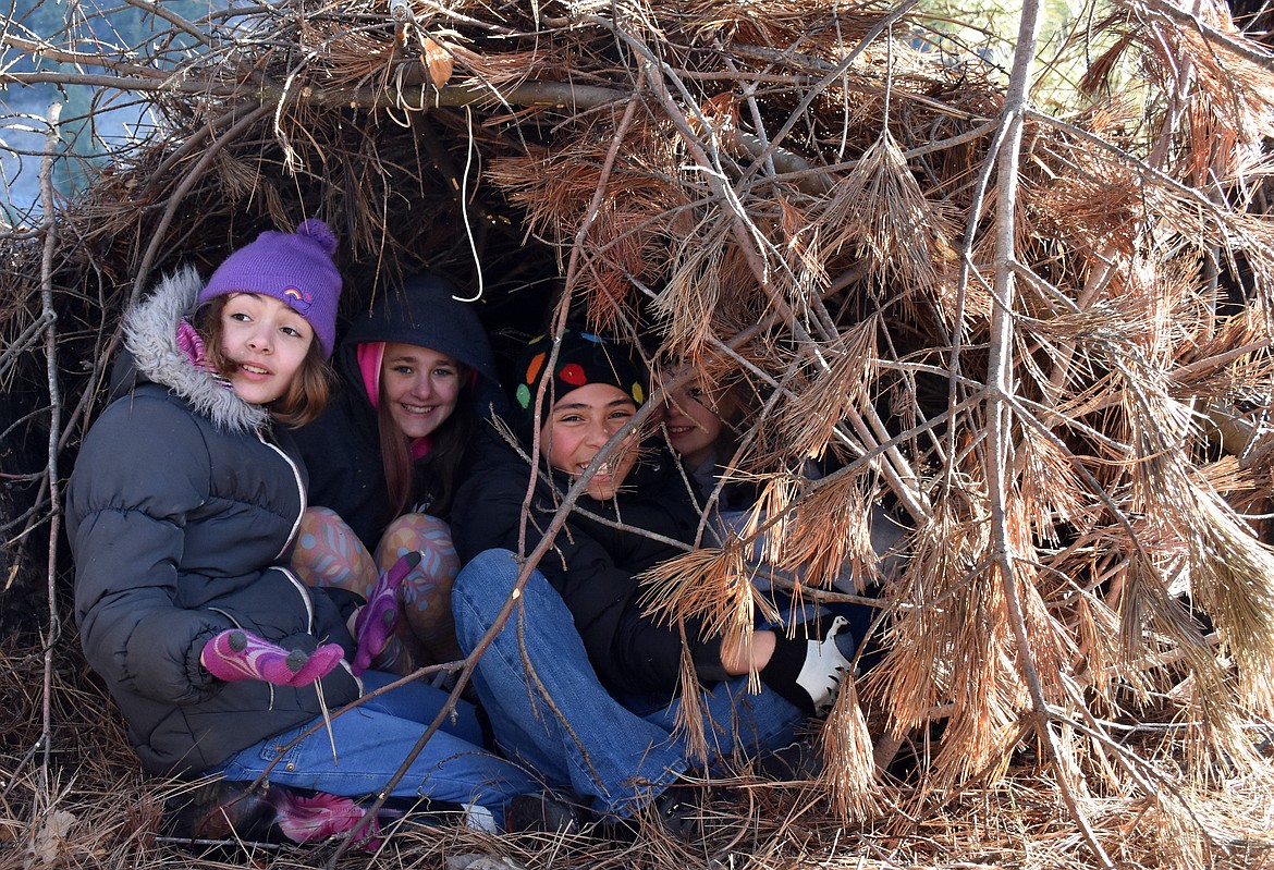 Troy Students crowd into a “debris hut” used for emergency shelter on Feb. 28 during a Winter Tracks outdoors education event offered by Friends of Scotchman Peaks Wilderness. (Duncan Adams/The Western News)