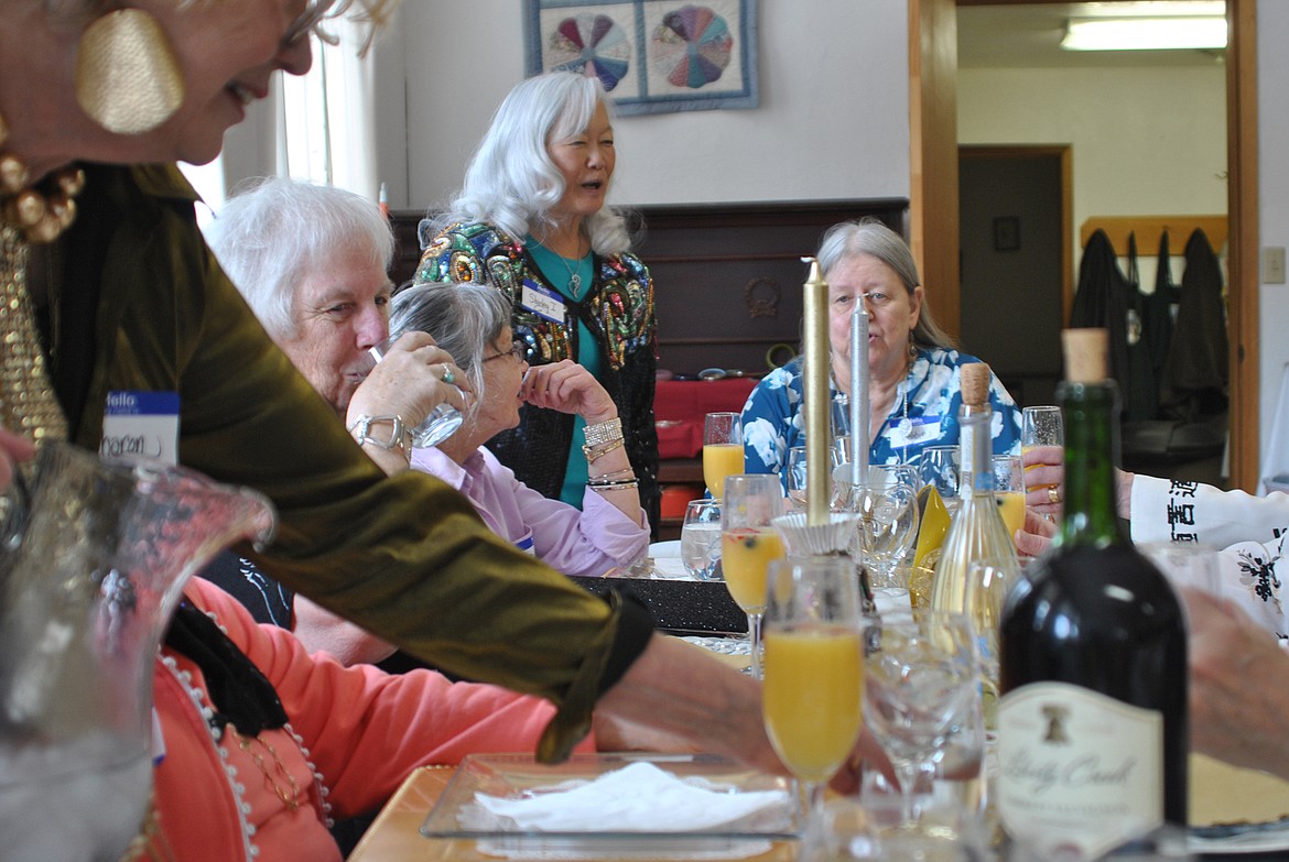 Sharon Korteum makes the rounds refreshing drinks for guests, while Shirley Iwatta mingles with friends at the Ladies Luncheon Feb. 29 at the Deborgia Schoolhouse. (Amy Quinlivan/Mineral Independent)