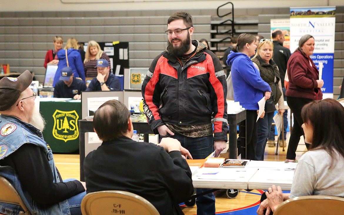 Elijah Miller, of Libby, visits with representatives from a local employer at the Columbia Falls Job Fair on March 5. (Mackenzie Reiss/Daily Inter Lake)