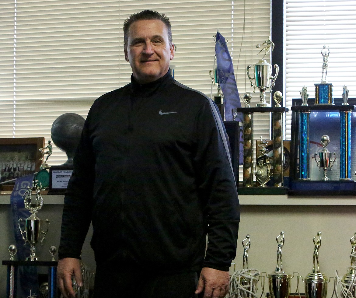 Big Bend athletic director Mark Poth stands in front of his numerous trophies won as the head men’s basketball coach for the college.