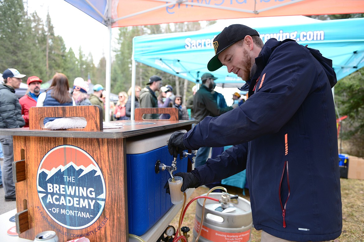 John Nelson, a program coordinator with Flathead Valley Community College's brewing science and brewery operations program, pours a beer for an attendee at the Bigfork Brewfest at the Harry Horn Day Use Area of Wayfarers State Park on Saturday, March 7. (Casey Kreider/Daily Inter Lake)