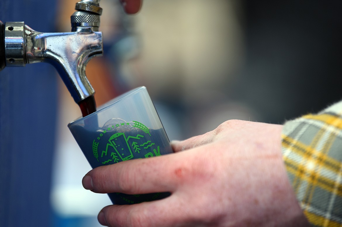 An attendee samples an Old Stache by Tamarack Brewing Company, one of several local brewers, at the Bigfork Brewfest at the Harry Horn Day Use Area of Wayfarers State Park on Saturday, March 7. (Casey Kreider/Daily Inter Lake)