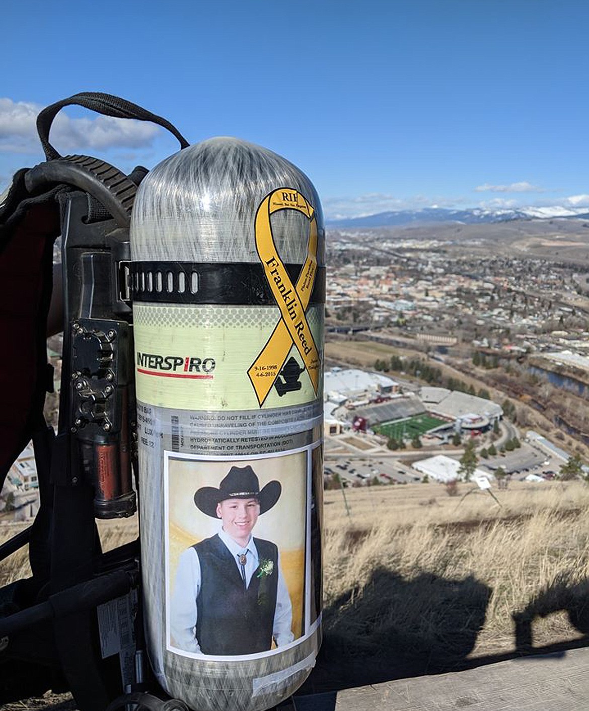 A photo of Franklin Reed is emblazoned on an oxygen tank of a Plains-Paradise fire fighter. Members of the department climbed Mount Sentinel in Missoula Sunday in memory of the junior firefighter who died of leukemia in 2015. (Photo courtesy Braden Starika)