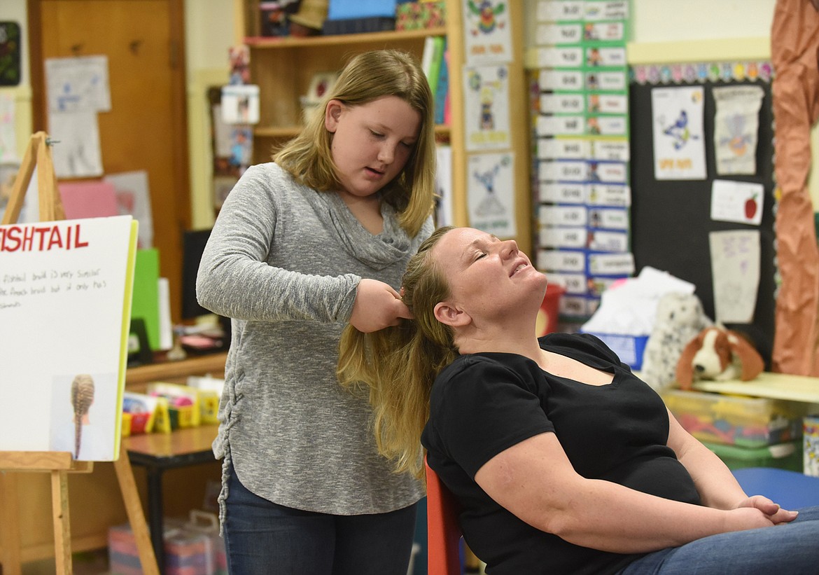 Madison Chojnacky, of Thompson Falls, braids her mother Shannon’s hair during her presentation last Saturday at the Sanders County 4-H Communication Day at Thompson Falls Elementary School. It was the beginning of the event that will end this weekend. (Scott Shindledecker/Valley Press)