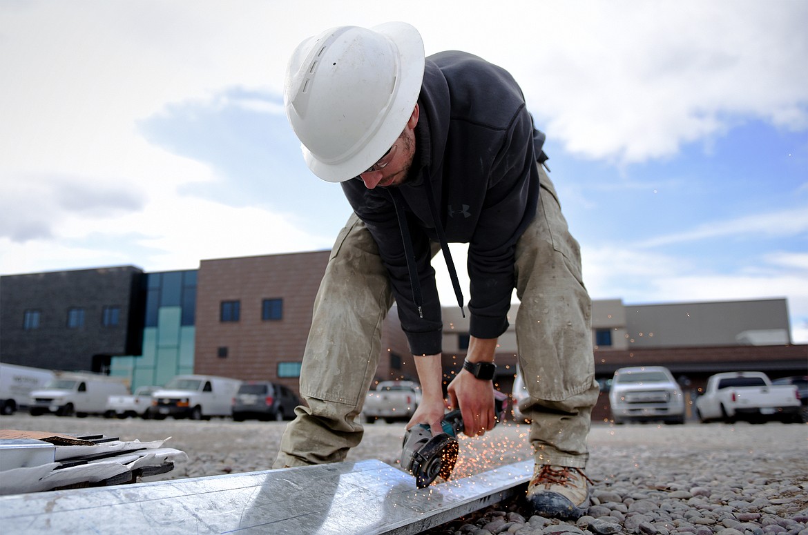 Jason Edwards, with Swank Enterprises, cuts steel studs used for the framing around a heating exhaust fan at Somers Middle School on Tuesday, March 11. (Casey Kreider/Daily Inter Lake)