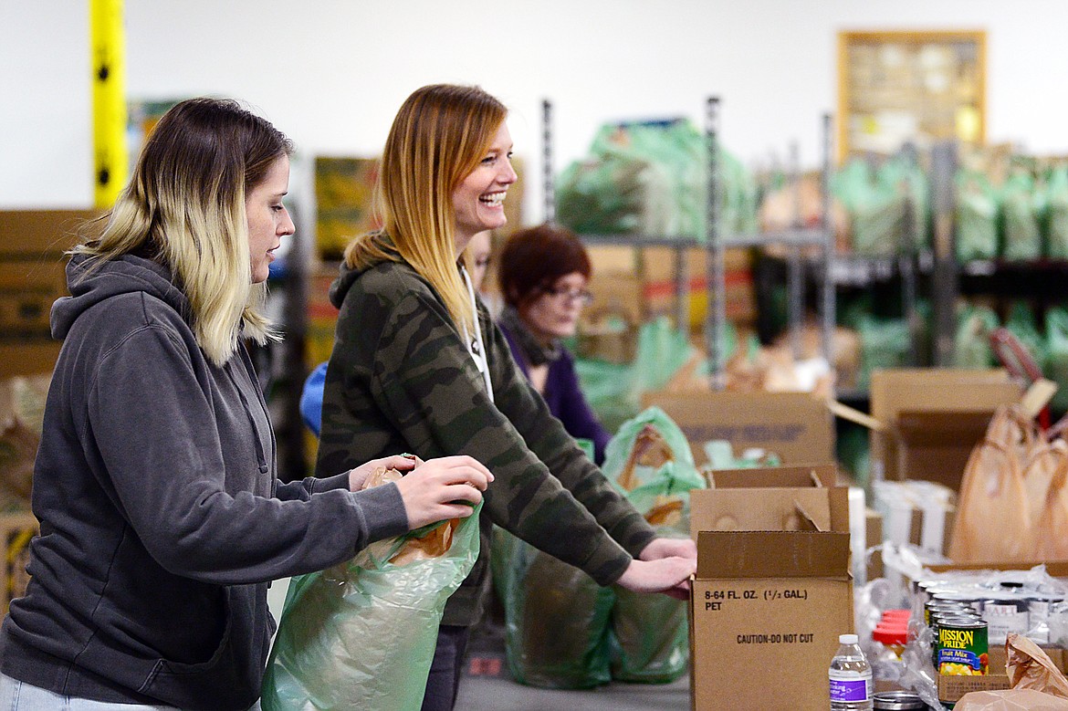 Janett Cantrell and members of Fresh Life Church put meals into bags for distribution at Flathead Food Bank on Tuesday, March 17. (Casey Kreider/Daily Inter Lake)