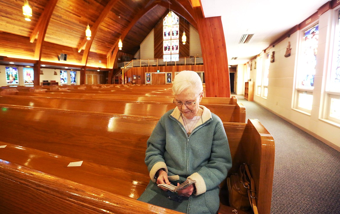Harriet Mize, of Columbia Falls, prays at Saint Richard Church in Columbia Falls on Thursday morning. Saint Richard, a Catholic church, is open for private prayer, limited to 10 people. (Mackenzie Reiss/Daily Inter Lake)