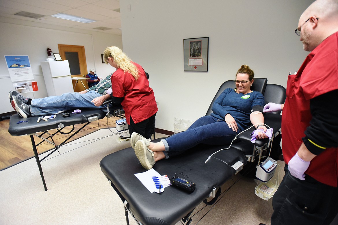 Mike Kelly, left, and Kelly Saari have blood drawn by collection specialists Kacey Evins and Bryan Catlin during a blood drive at the American Red Cross Blood Donation Center at 126 N. Meridian Road in Kalispell on Friday. The Red Cross has increased sanitization measures and is taking temperatures of potential donors at the door due to the coronavirus pandemic. They’ve also updated their hours to remain open from 9 a.m. to 6 p.m. everyday. (Casey Kreider/Daily Inter Lake)