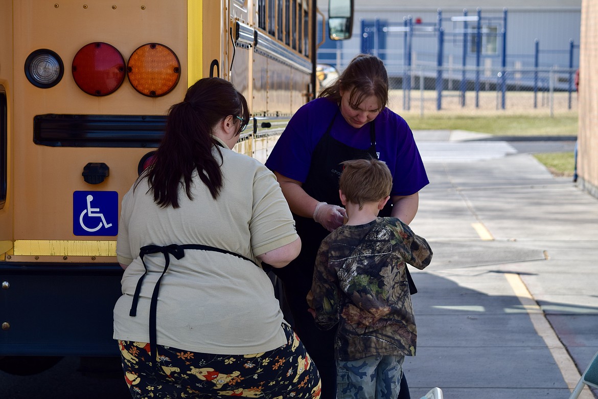 Charles H. Featherstone/Columbia Basin Herald 
 Frontier Middle School Head Cook Kimberly Levi, facing forward, and food service specialist Breanna Murray help a Midway Elementary student get lunch.