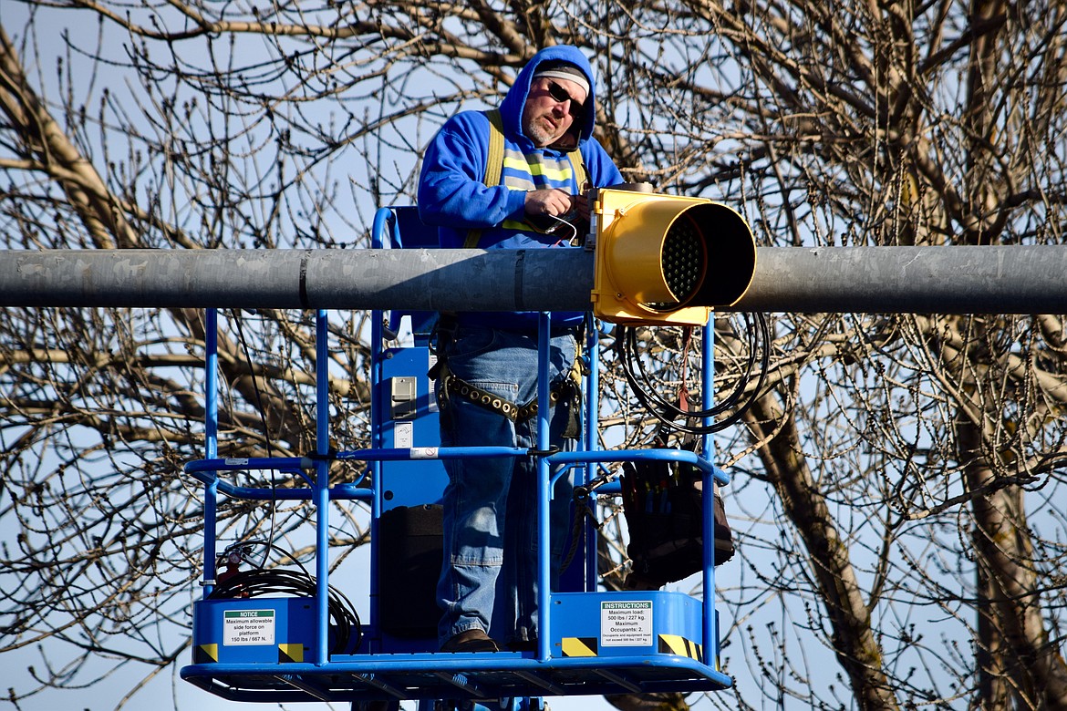 Charles H. Featherstone/Columbia Basin Herald 
 Jerry Beaudry, an electrician with Transportation Systems in Sumner, rewires a street crossing light on Friday.