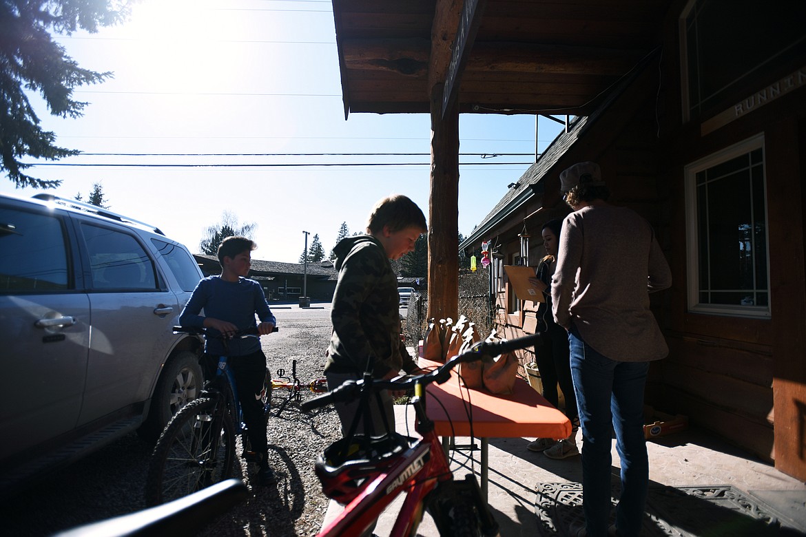 Youngsters pull up on their bikes during a grab and go meal distribution at Bigfork ACES on Wednesday, March 18. (Casey Kreider/Daily Inter Lake)