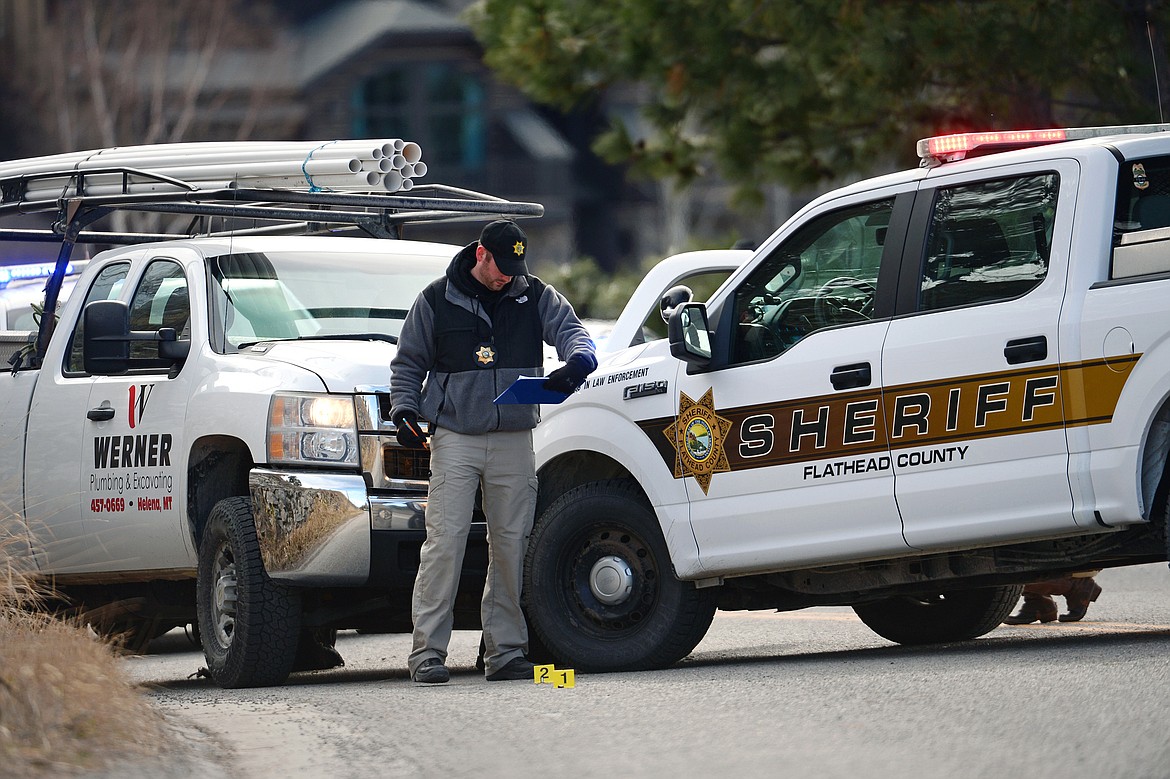 An investigator with the Flathead County Sheriff's Office works the scene of an officer-involved shooting involving a pursuit of a stolen truck that ended along Grand Drive in Bigfork on Tuesday morning. Kalispell Police Department was also involved in the investigation. (Casey Kreider/Daily Inter Lake)