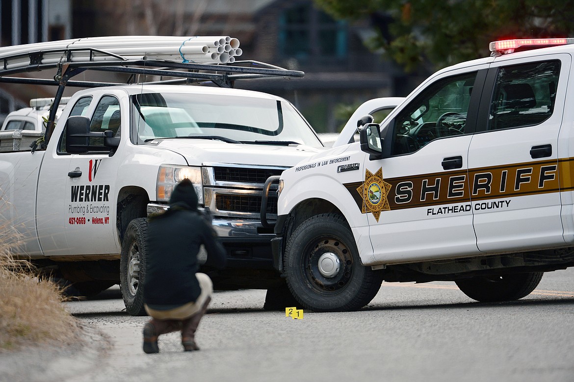An investigator with the Flathead County Sheriff's Office photographs the scene of an officer-involved shooting involving a pursuit of a stolen truck that ended along Grand Drive in Bigfork on Tuesday morning. Kalispell Police Department was also involved in the investigation. (Casey Kreider/Daily Inter Lake)
