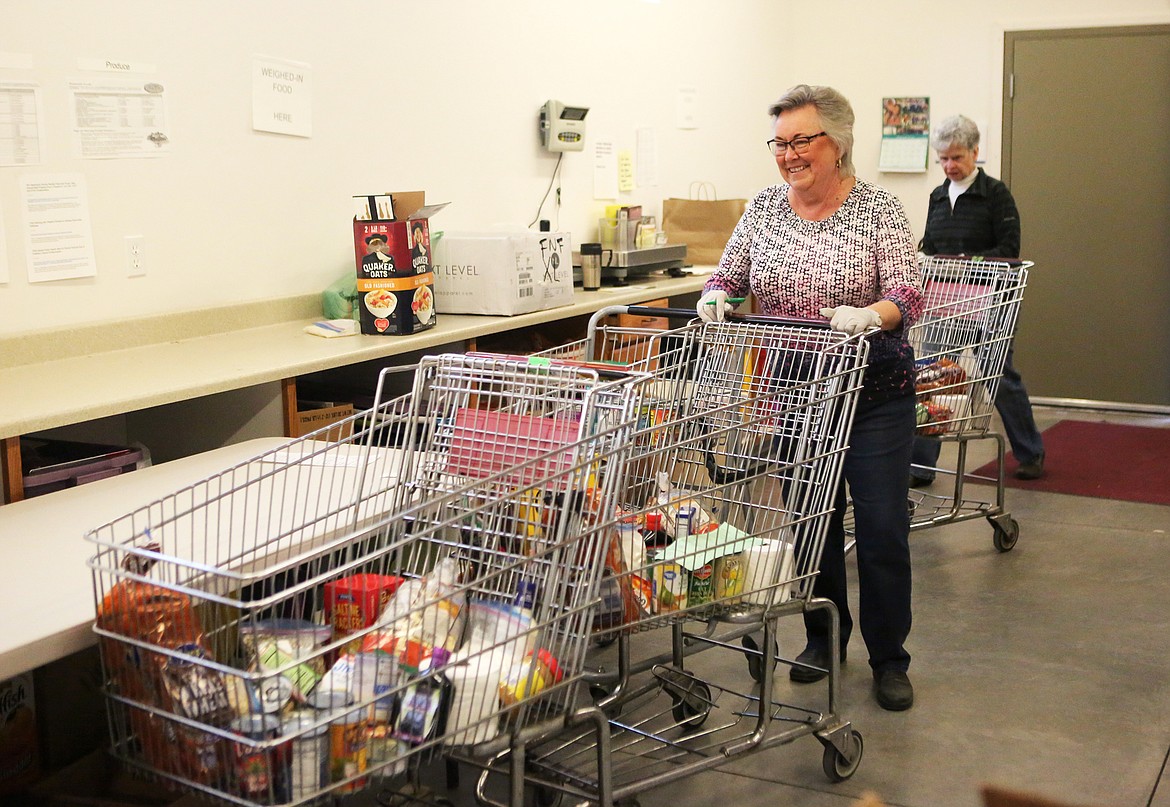 Arlene Wilson, of Bigfork, helps prepare packaged boxes of food for customers of the Bigfork Food Bank. The food bank transitioned to pre-packaged boxes to help curtail the spread of COVID-19. (Mackenzie Reiss/Bigfork Eagle)