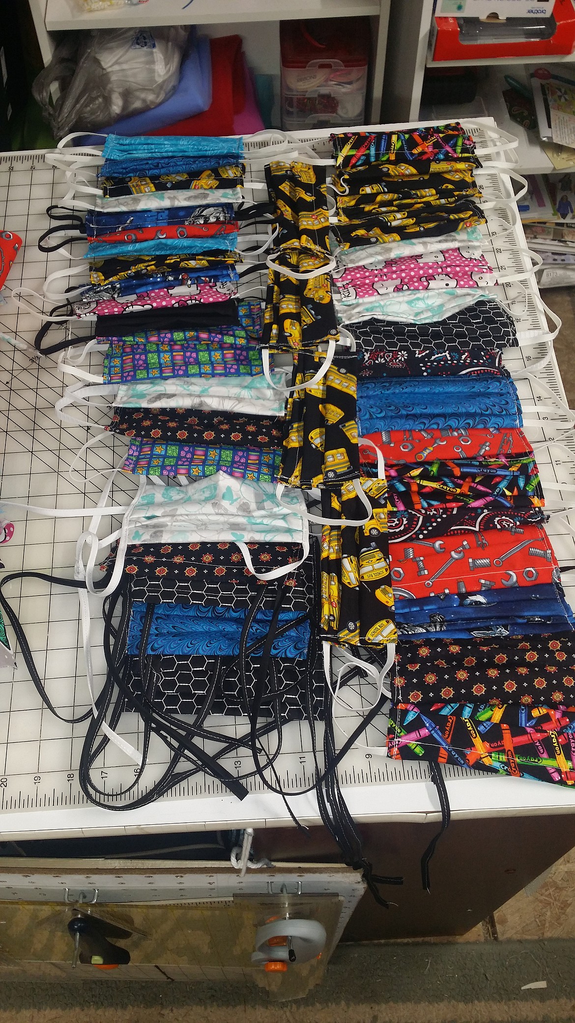 Courtesy photo 
 Susan Jungers stacks her colorfully-patterned face masks into two neat piles. Like many of the other volunteer mask makers, Jungers has been using a wide variety of fabrics during her craft.