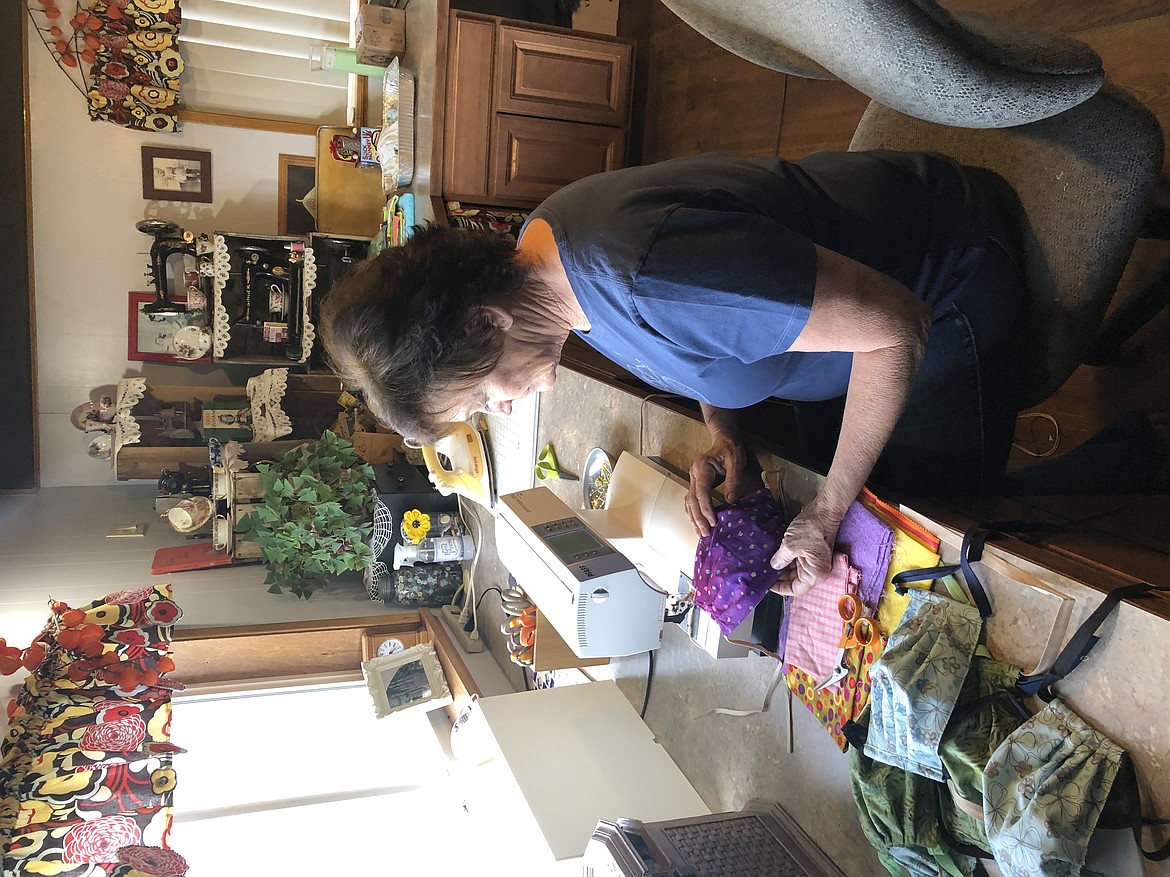 Sue Tebow sits at her sewing machine at home Tuesday, cranking away at her pile of homemade masks. With the help of others in the community, Tebow is working to help supplement the supply of masks for healthcare works and others impacted by the coronavirus outbreak, due to a severe shortage in industry-grade masks.