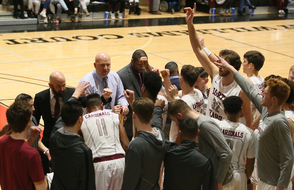North Idaho College men’s basketball coach Corey Symons, center, gives last minute instructions during a timeout in a game against the Community College of Spokane in 2018. NIC coaches have been forced to get creative with how they recruit athletes with campus visits banned during the coming weeks due to the coronavirus pandemic.
