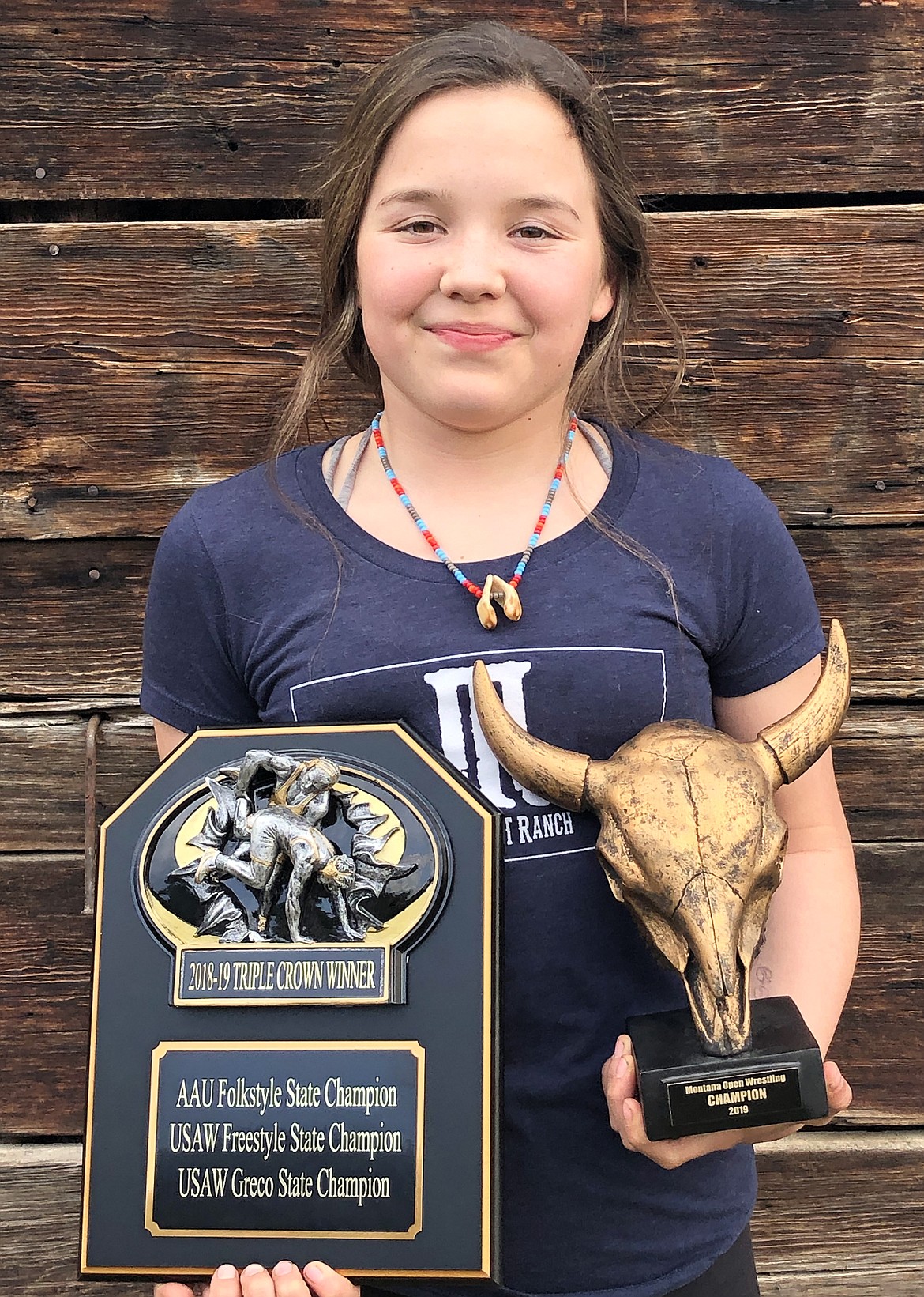 Brynn Courville with her AAU/USA-W 2018-19 Triple Crown trophy and 2019 Montana Open Champion trophy. (Photo provided by Brynn Courville)