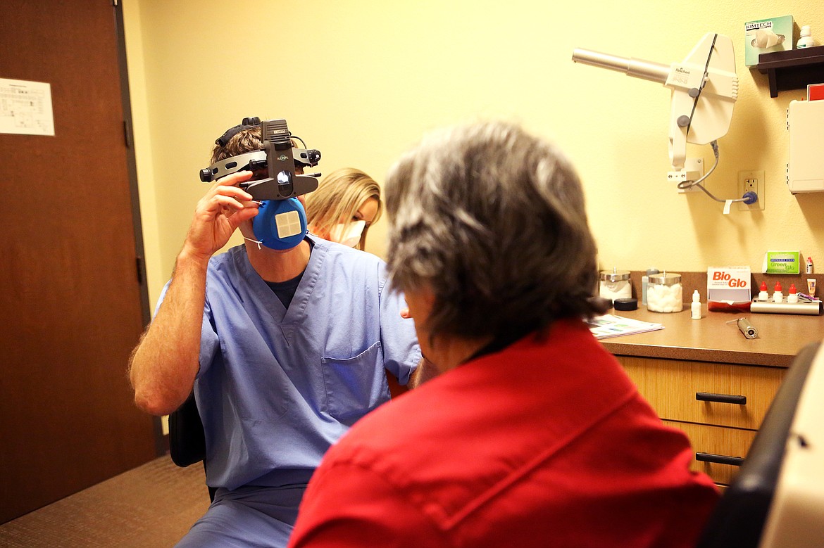 Doctor Tyler Ofstad uses an N95 mask made from a 3D printer during a visit with a patient at Glacier Eye Clinic on Thursday. (Mackenzie Reiss/Daily Inter Lake)