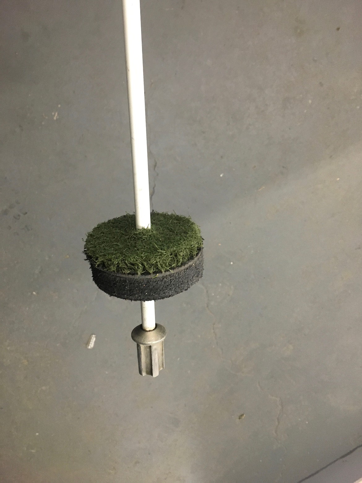 Another look at the cut-up piece of an old driving range mat, placed around the flagstick to keep the ball from falling to the bottom of the cup.