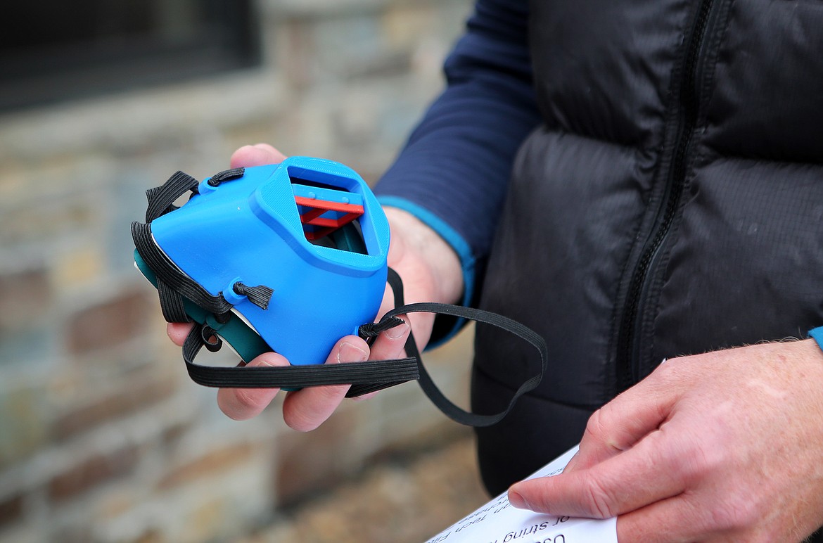 Todd Spangler gives Ryan Zebro with the Whitefish Police Department a closer look at the 3-D printed masks. (Mackenzie Reiss/Daily Inter Lake)