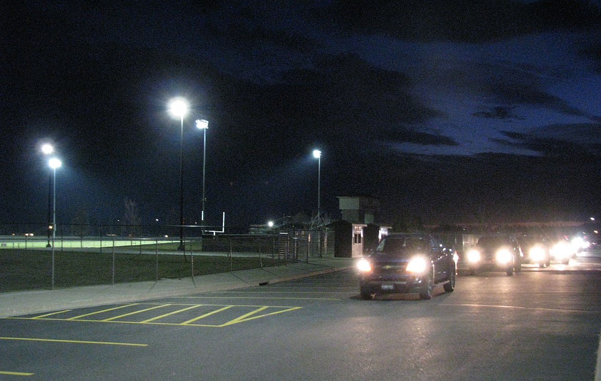 A line of cars rolls past Trojan Stadium at Post Falls High School on Friday night, as part of the #BeTheLight campaign to honor high school seniors — athletes and other students — who saw their spring activities canceled by the coronavirus pandemic. At the #BeTheLight campaign which took place at most schools throughout the state, as well as in several other states, stadium lights were turned on at 8:20 p.m. for 20 minutes, during which time cars drove through the parking lot, many with their horns blaring. At Post Falls, cars started showing up a good 20 minutes before the lights came on, and several hundred cars participated — many making the loop through the school lot more than once. Even after the stadium lights were turned off at 8:40, cars continued to snake through the lot for another 5 minutes.