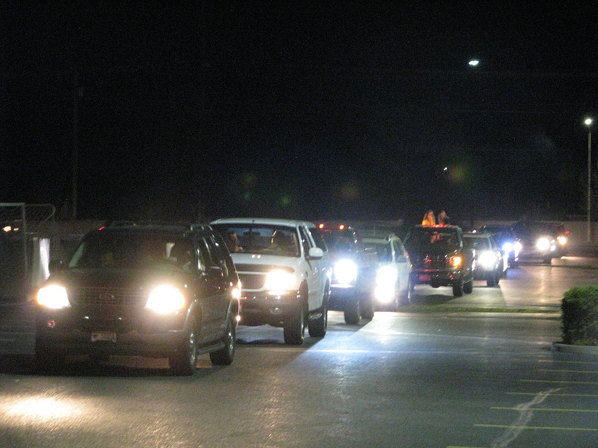 In a scene replicated at many other high schools around the state and the country, cars line up at Post Falls High School to roll past Trojan Stadium for the #BeTheLight campaign to honor high school seniors missing out on spring activities in April.