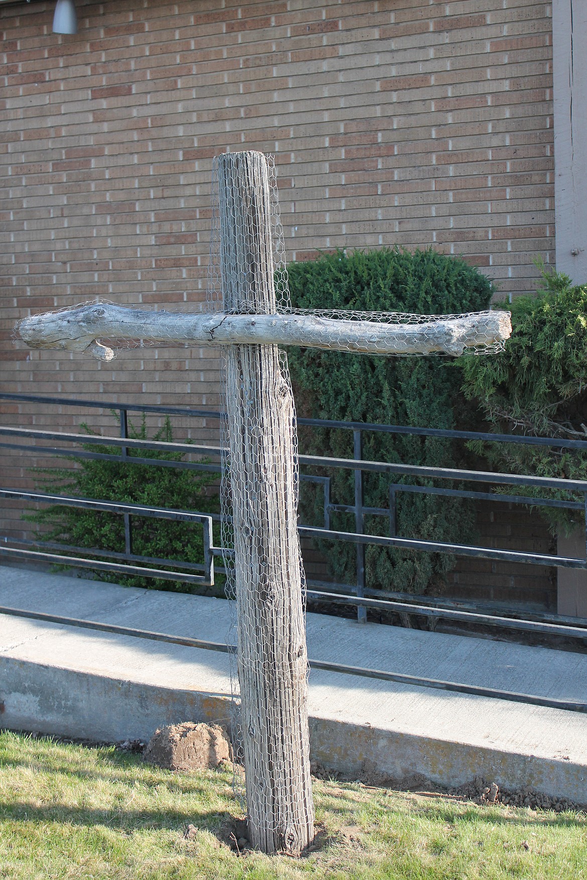 The bare wood cross, covered in chicken wire, stands outside Immanuel Lutheran Church on Good Friday, waiting to be decorated.