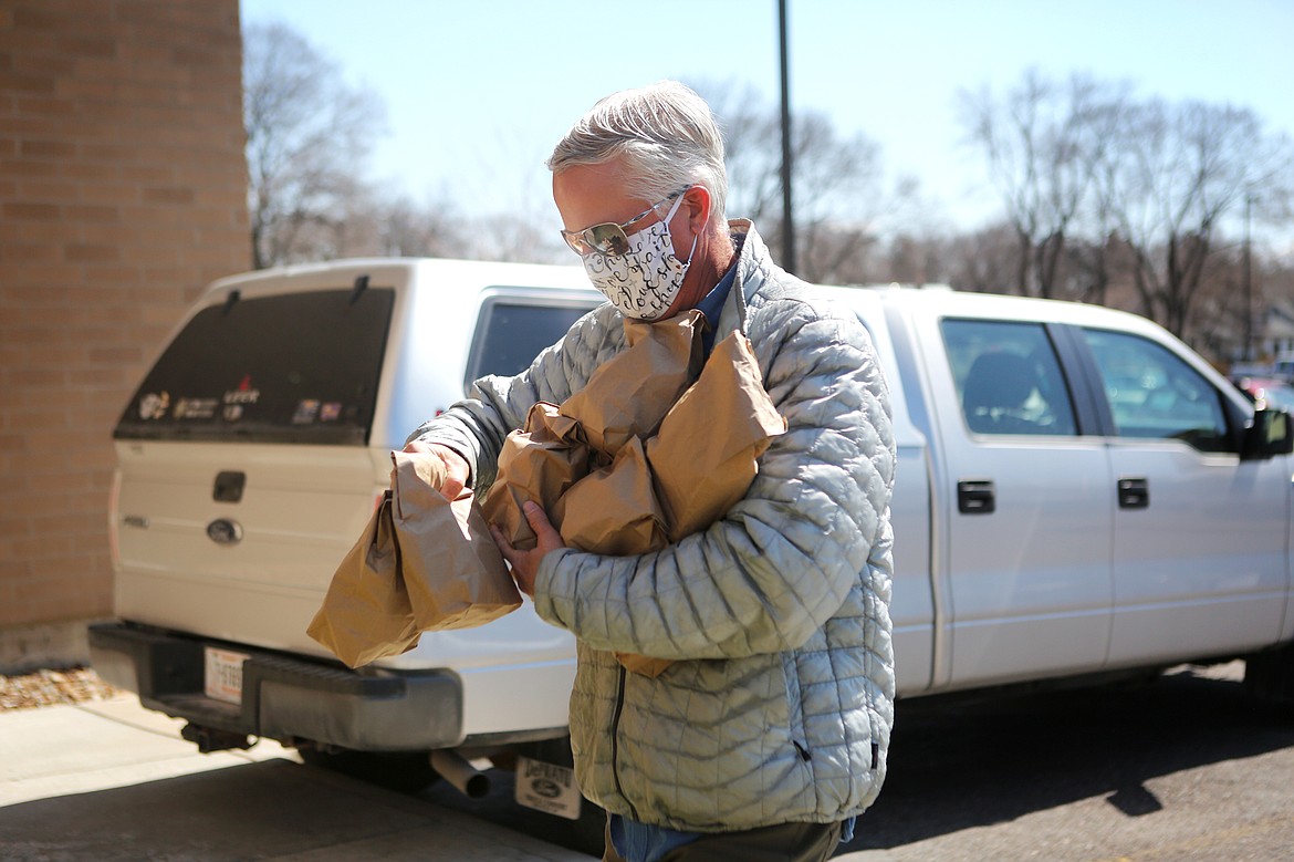 CrossRoads Christian Fellowship Pastor Randy Passons carries a load of meals into the Flathead County Sheriff’s Office on Thursday. (Mackenzie Reiss/Daily Inter Lake)