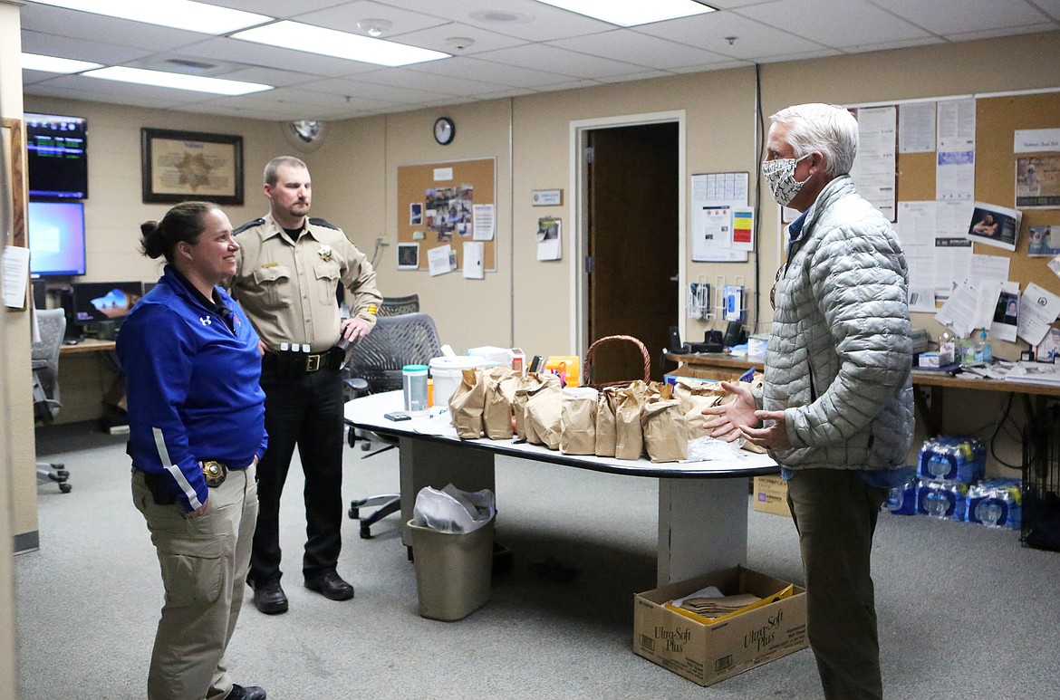 CrossRoads Christian Fellowship Pastor Randy Passons, right, chats with Deputy Paula Sullivan and Flathead County Sheriff Brian Heino after dropping sacks of snacks last Thursday. (Mackenzie Reiss/Daily Inter Lake)