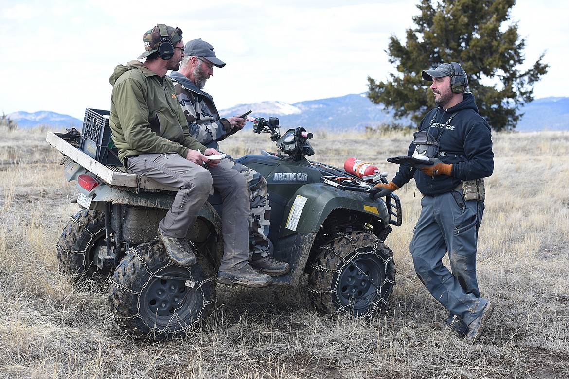 Match winner Jared Miller (left) and Whitefish shooter Corey Harris (right) check in with match director Mark Griffis between stages.