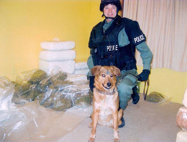 Jason Johnson, sporting a wide grin, poses next to one of K-9 Flash’s finds after serving a SWAT search warrant in 2008.