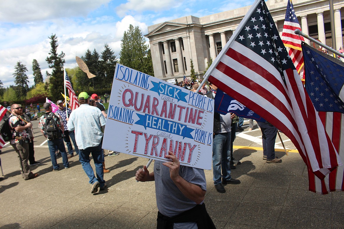 Cameron Sheppard/WNPA News Service 
 Protestors to Inslee’s “stay home, stay healthy,” order hold signs in front of the legislative building.