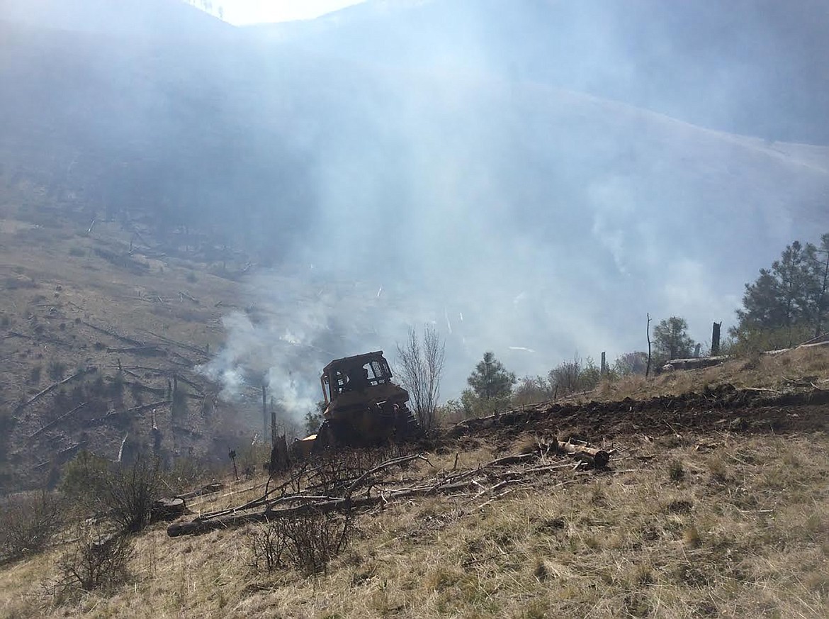 A Montana Department of  Natural Resources and Conservation bulldozer works to build fire lines in the Henry Creek drainage in Sanders County Tuesday. Officials said the 40-acre blaze burned through mostly grass and dead timber from the 1998 Boyer Creek Fire. (Photo courtesy U.S. Forest Service)