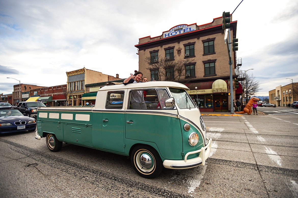 Passengers wave from a classic Volkswagen during the Kruise Kalispell event on Main Street on Friday, April 17. (Casey Kreider/Daily Inter Lake)