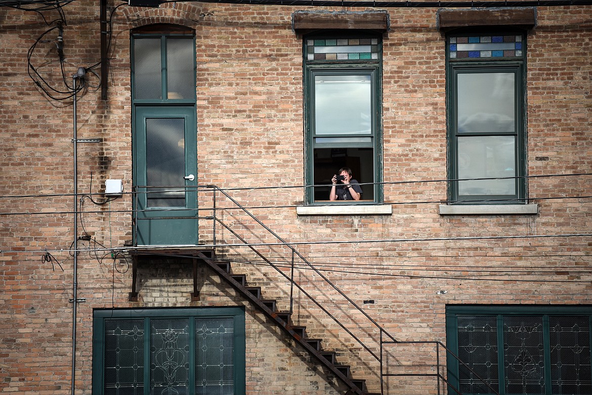 A spectator watches the Kruise Kalispell event from a second story window on Friday, April 17. (Casey Kreider/Daily Inter Lake)