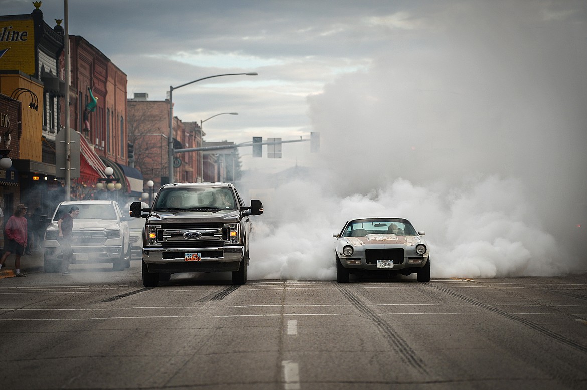 Vehicles spin their tires at a traffic light on Main Street during the Kruise Kalispell event on Friday, April 17. (Casey Kreider/Daily Inter Lake)