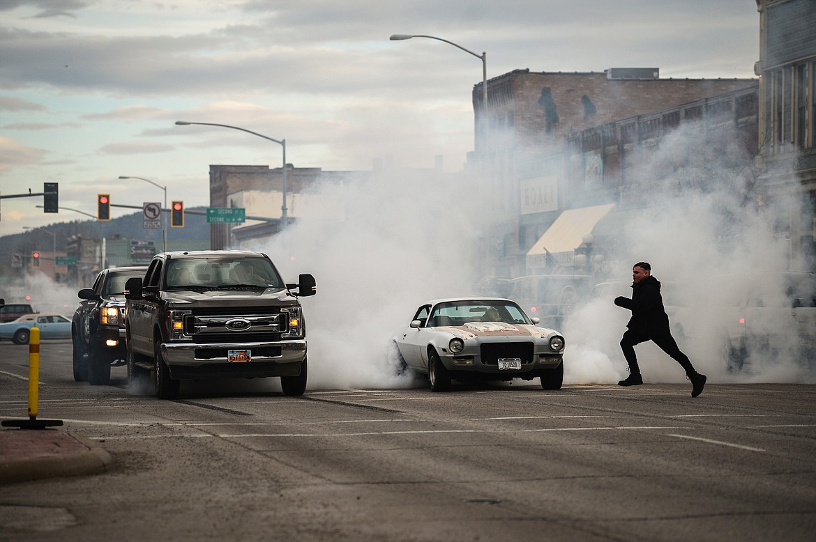 Vehicles spin their tires at a traffic light on Main Street during the Kruise Kalispell event on Friday, April 17. (Casey Kreider/Daily Inter Lake)