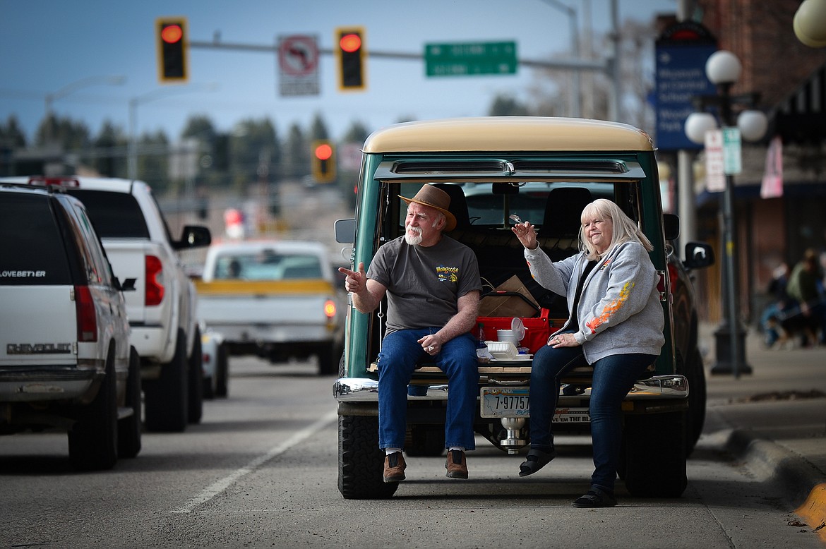 Mike and Jenise Lithgow, of Kila, wave to passing vehicles along Main Street during the Kruise Kalispell event on Friday, April 17. (Casey Kreider/Daily Inter Lake)