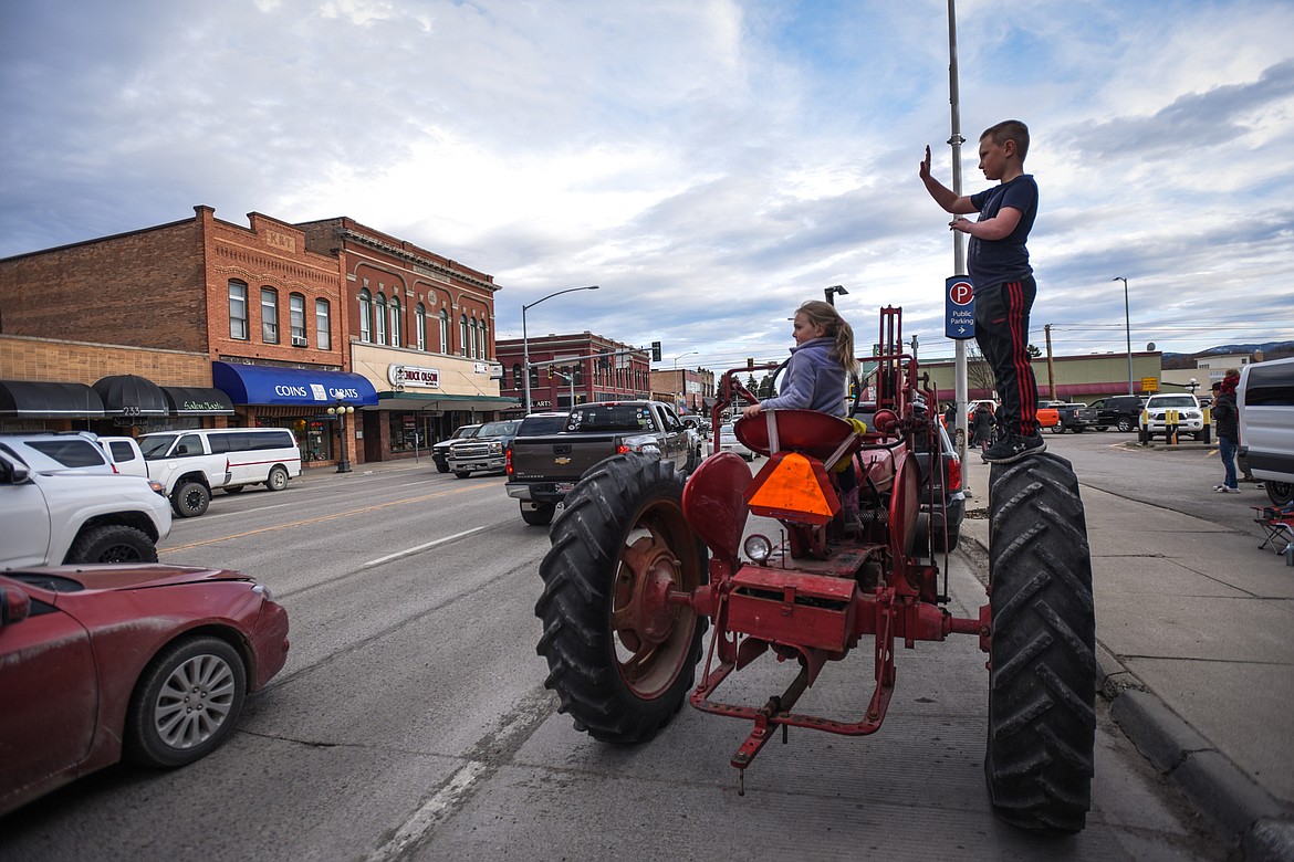 Children watch the Kruise Kalispell event along Main Street from a 1947 Farmall International tractor on Friday, April 17. (Casey Kreider/Daily Inter Lake)