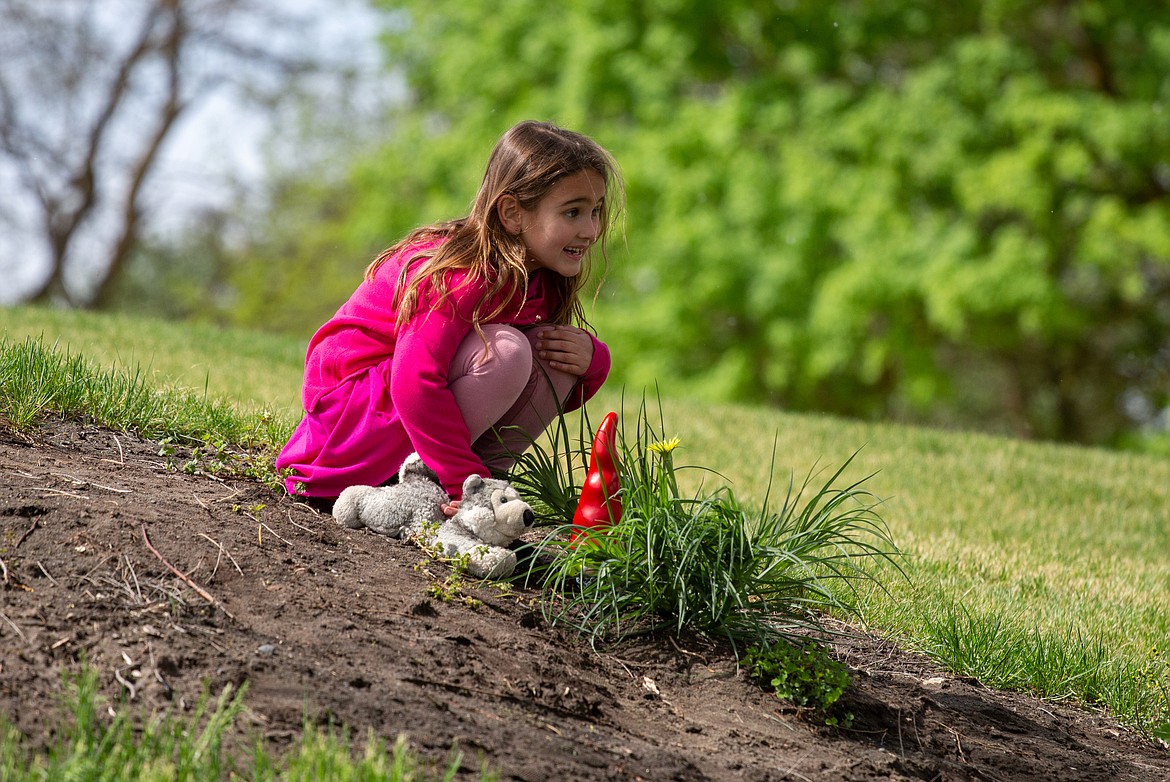 Autumn Anderson smiles with the gnome statue at Blue Heron Park after finding it for the Gnome Scavenger Hunt with her mom, Gwen Anderson, on Thursday morning.