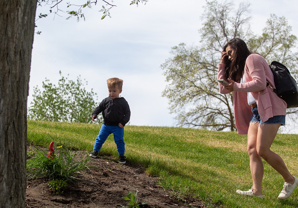 Vincent Monnone, 1, points with excitement to the gnome statue as his mom, Catherina Monnone, makes her way over to take a selfie for the Gnome Scavenger Hunt on Thursday at Blue Heron Park.