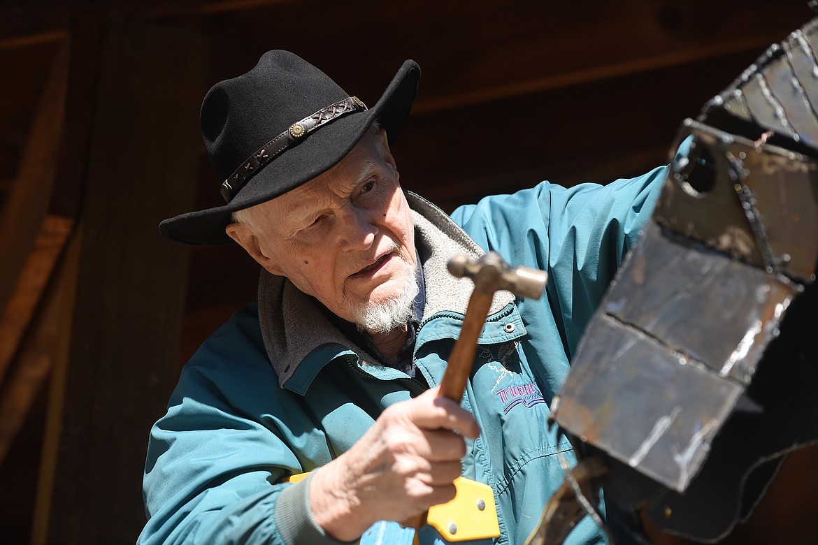 Plains artist Kenton Pies tinkers on a metal horse he is building.