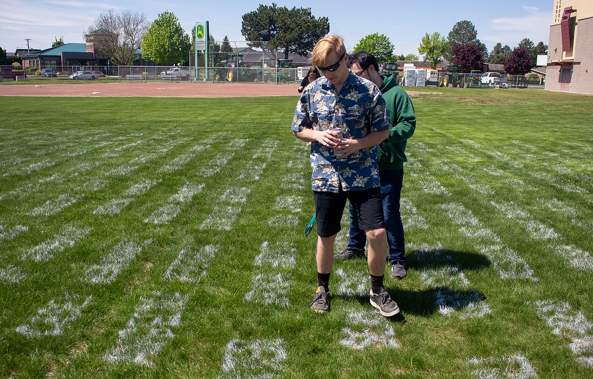 Moses Lake senior Dylan Huber looks down at the names of classmates as he makes his way around the Field of Chiefs, a project launched to honor the class of 2020 in Moses Lake.