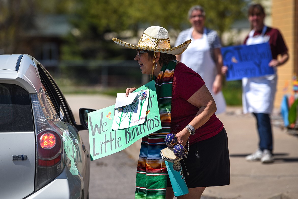 Kindergarten teacher Sue Stephens greets a student and parent during a Cinco de Mayo Parade for teachers, students and staff outside Swan River School in Bigfork on Tuesday. (Casey Kreider/Daily Inter Lake)