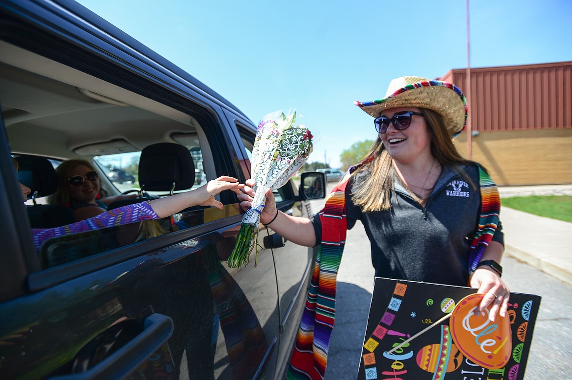 Paraeducator Dylan Quinn receives a bouquet of flowers from a student during a Cinco de Mayo Parade for teachers, students and staff outside Swan River School in Bigfork on Tuesday. (Casey Kreider/Daily Inter Lake)