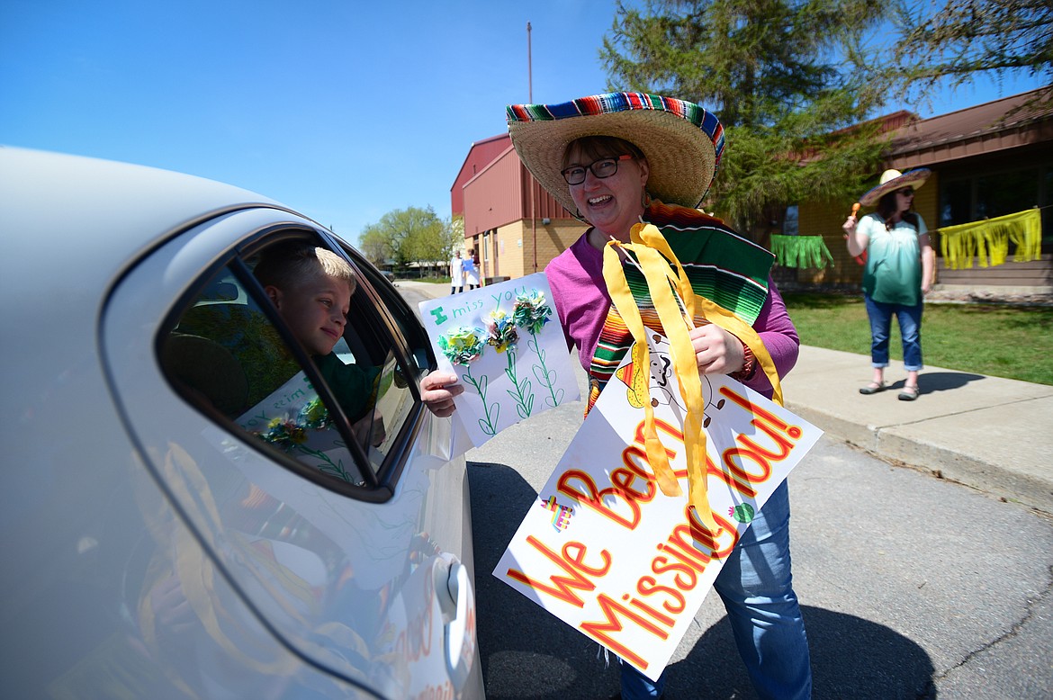 Second-grade teacher Sherry Bradstreet receives a decorative drawing from a student during a Cinco de Mayo Parade outside Swan River School in Bigfork on Tuesday. (Casey Kreider/Daily Inter Lake)