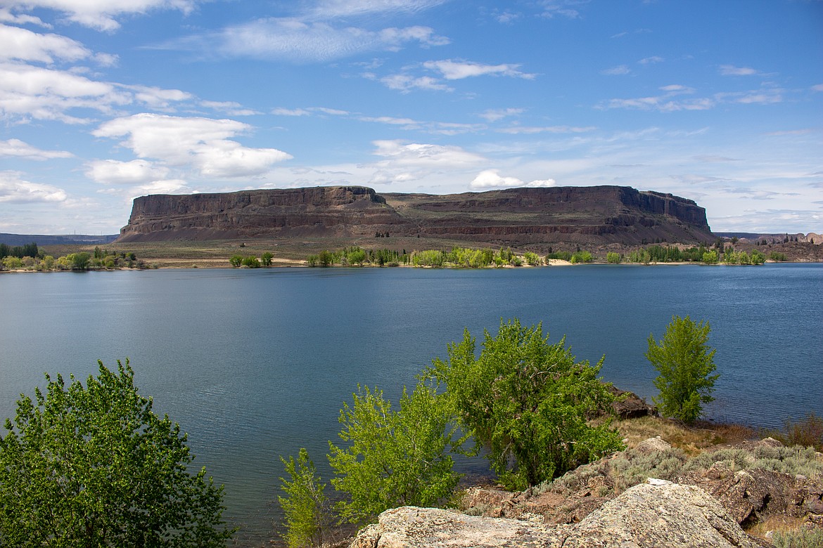 Standing alone in the distance, Steamboat Rock towers above the water and scrublands beneath it inside the state park named for the geological formation.