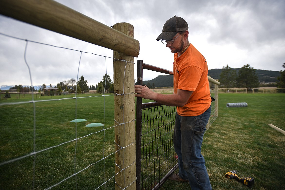 Jacob Christman, of Mild Fence Company, attaches a gate to a client’s fence during an installation in Kalispell on Wednesday, May 6. (Casey Kreider/Daily Inter Lake)